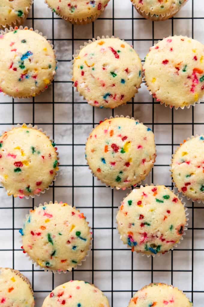 A close up image of moist funfetti cupcakes cooling on a rack.