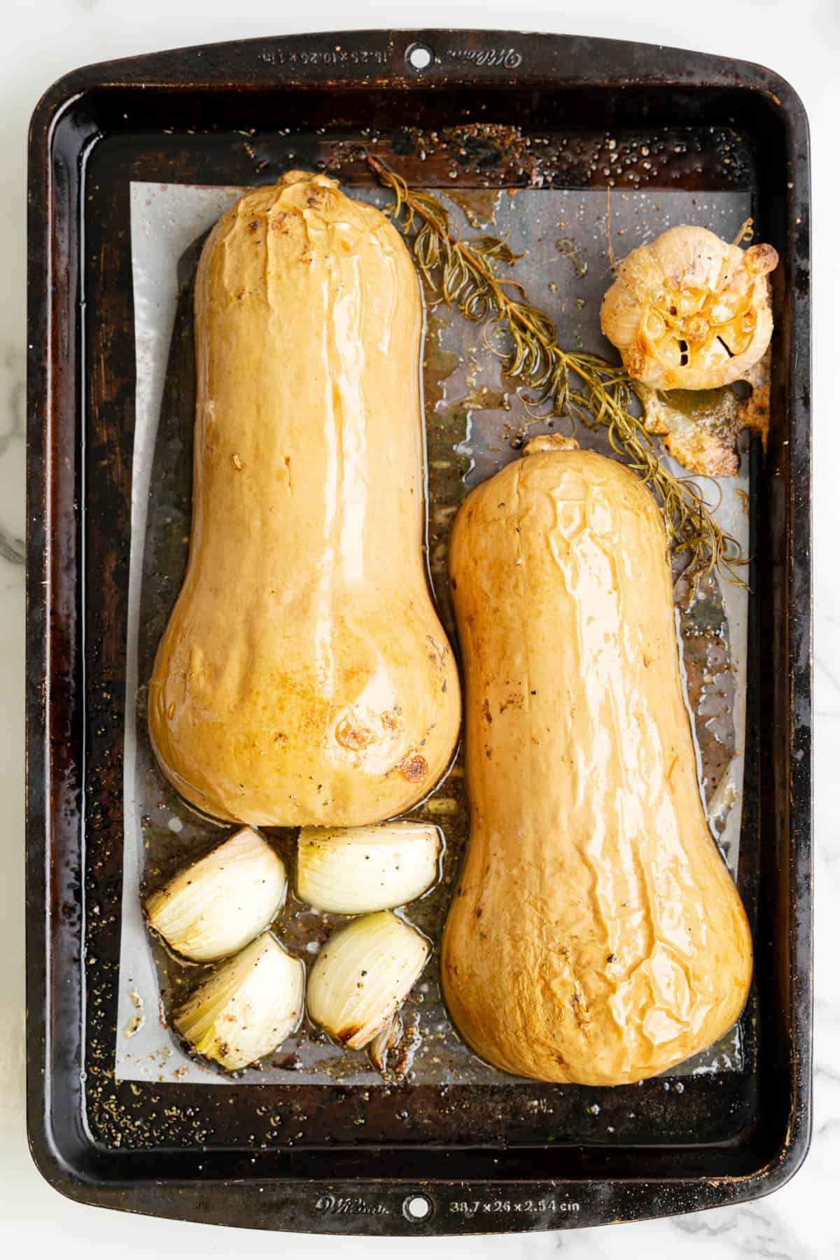 Roasted butternut squash and other vegetables on a baking sheet.
