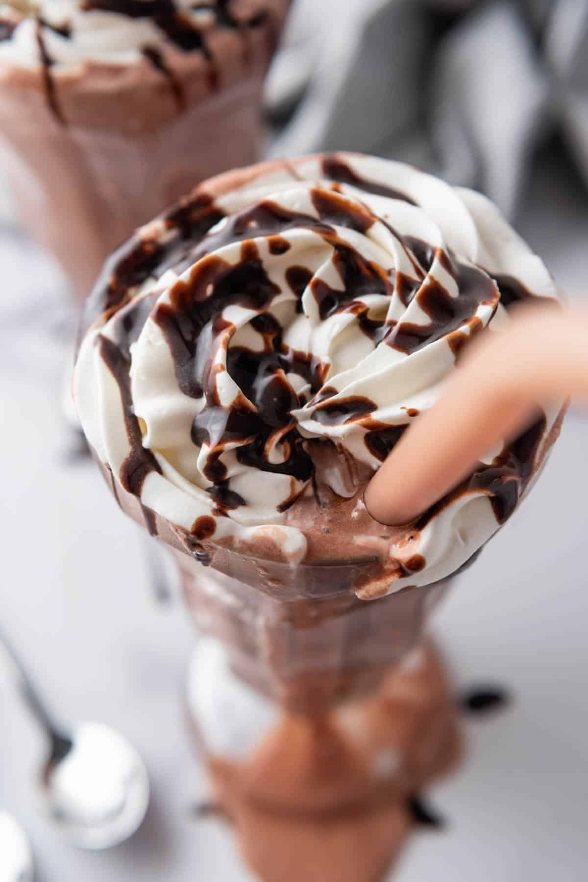 An overhead image of a chocolate milkshake with a straw in it.