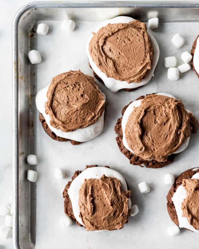 An overhead image of chocolate marshmallow cookies with chocolate frosting.