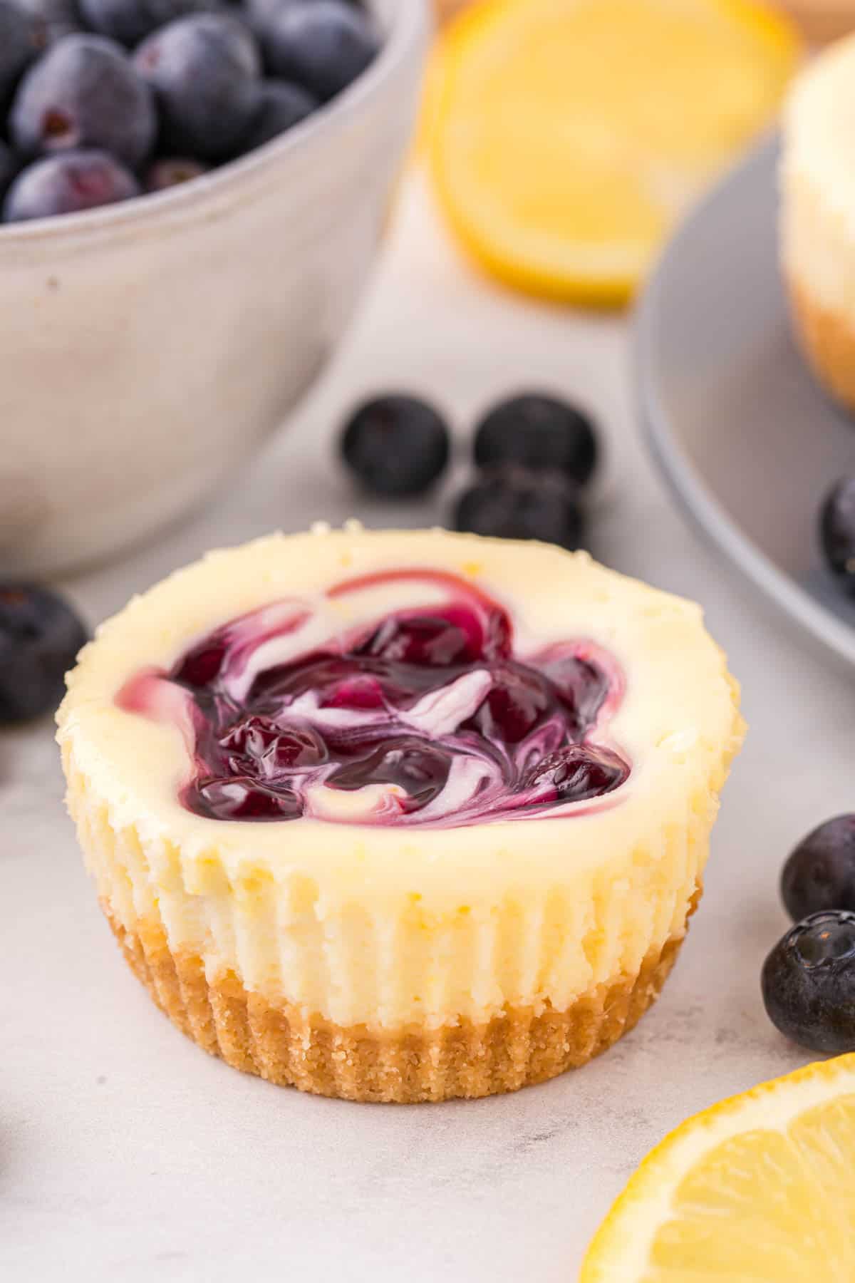A mini lemon blueberry cheesecake with nilla wafer crust.