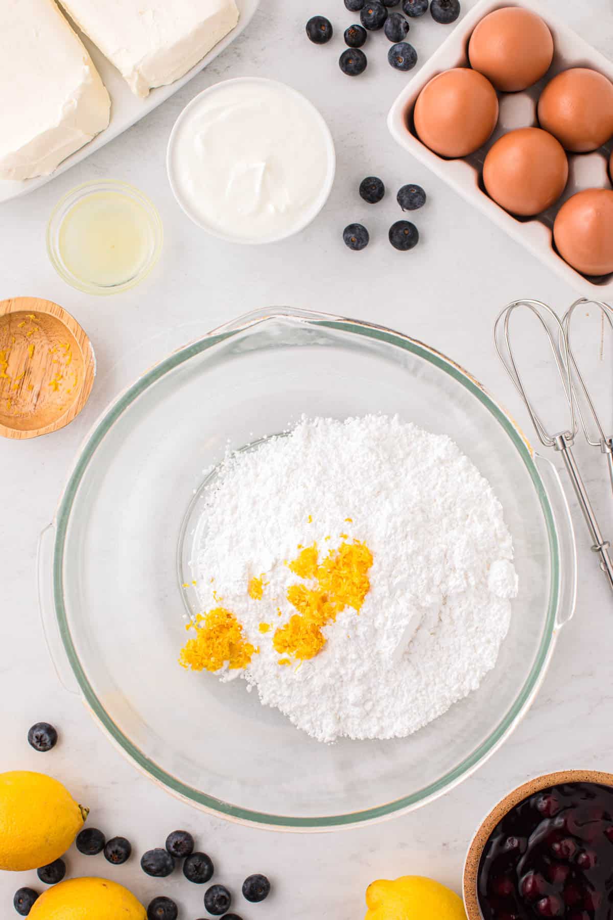 Combining lemon zest and powdered sugar in a bowl.