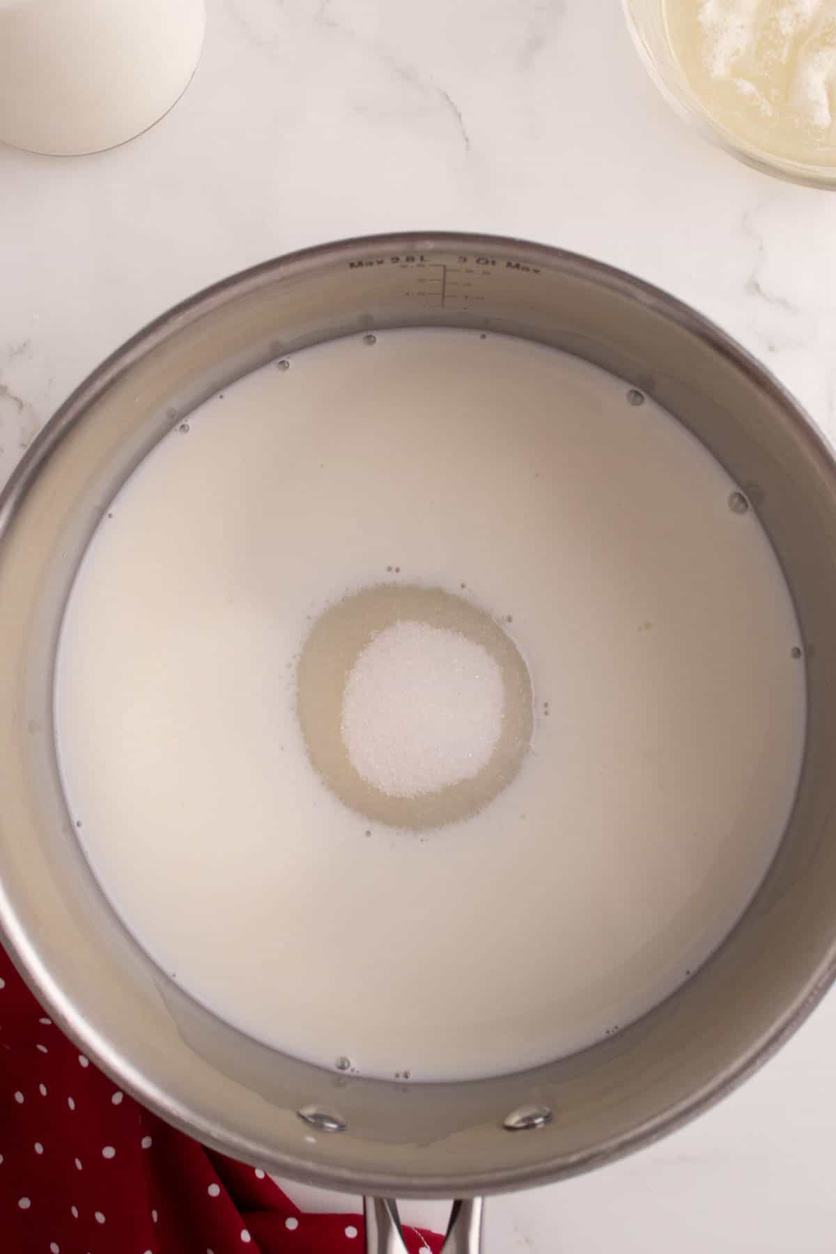 Combining milk and sugar in a saucepan.
