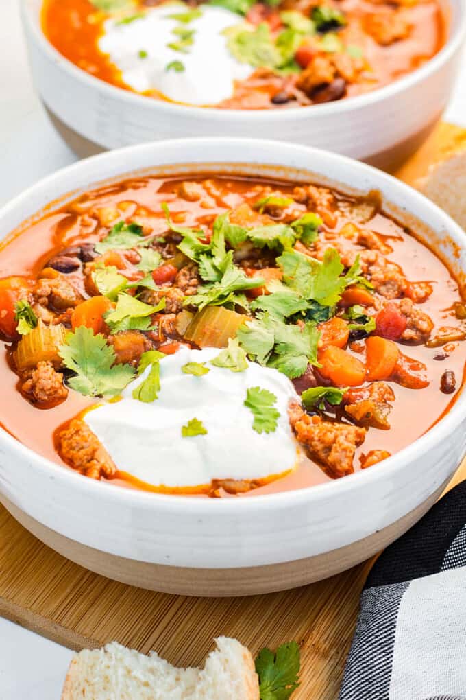 A bowl of pumpkin turkey chili topped with sour cream and cilantro.