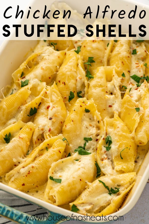 A pan of chicken alfredo stuffed shells with text overlay.