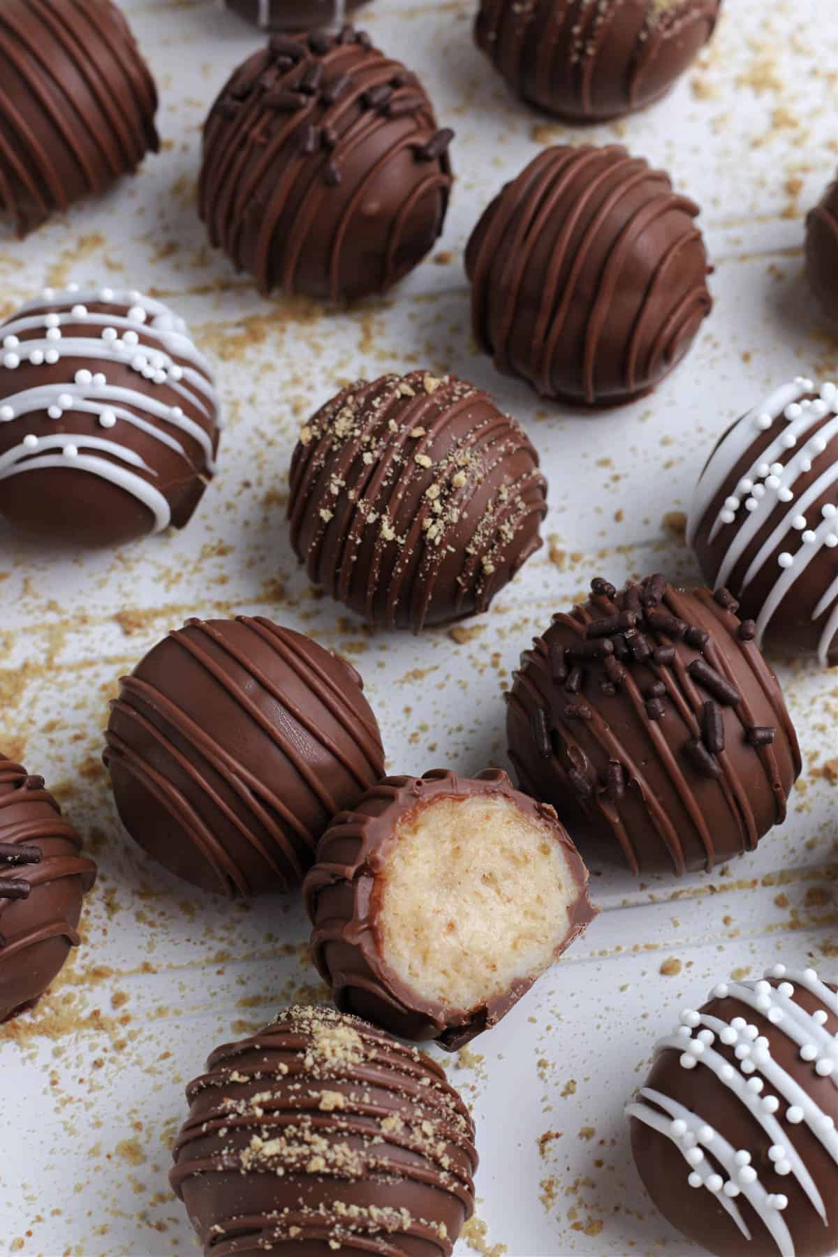 Cheesecake truffles with one of them cut in half.