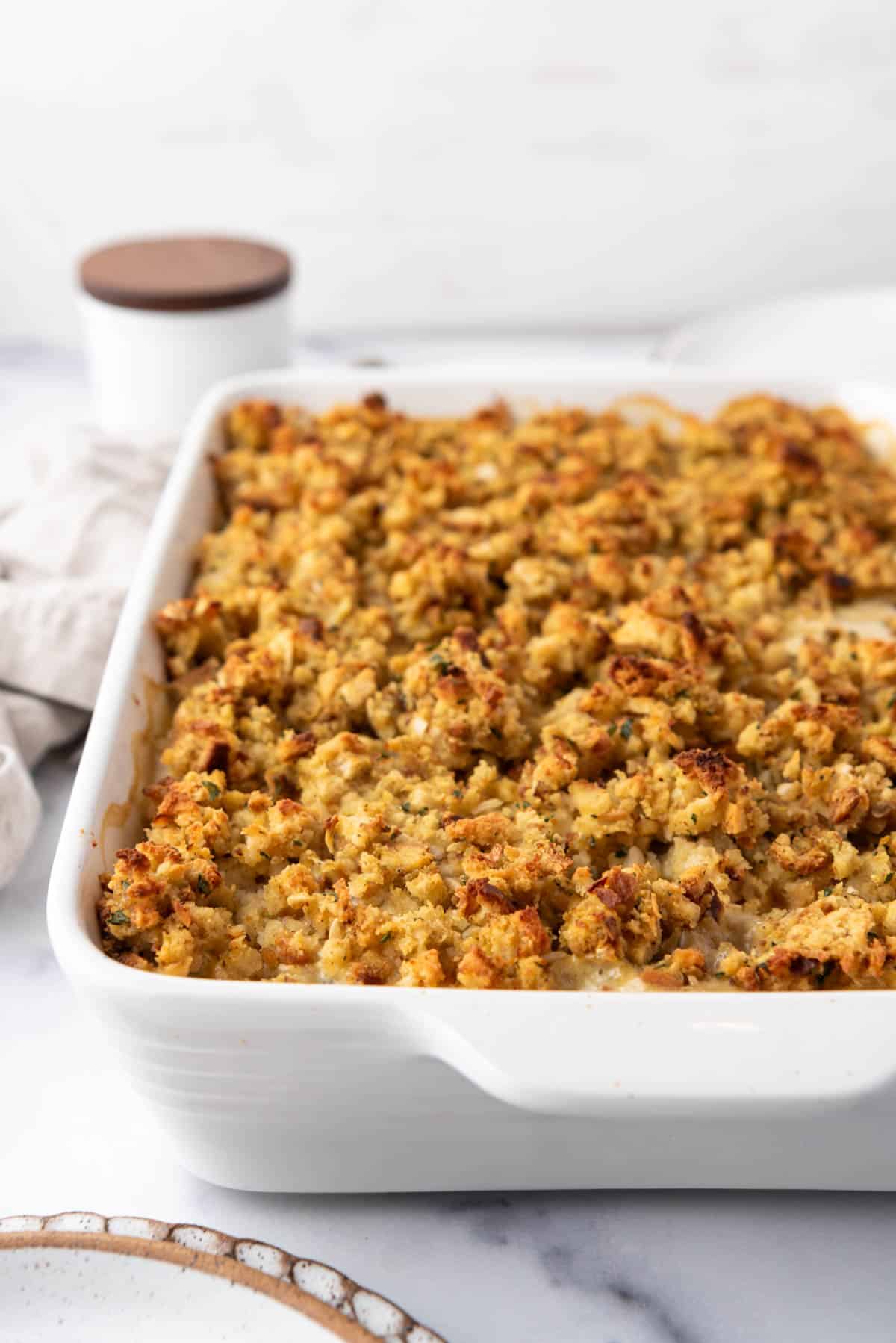 A baked chicken and stuffing casserole in a white baking dish.