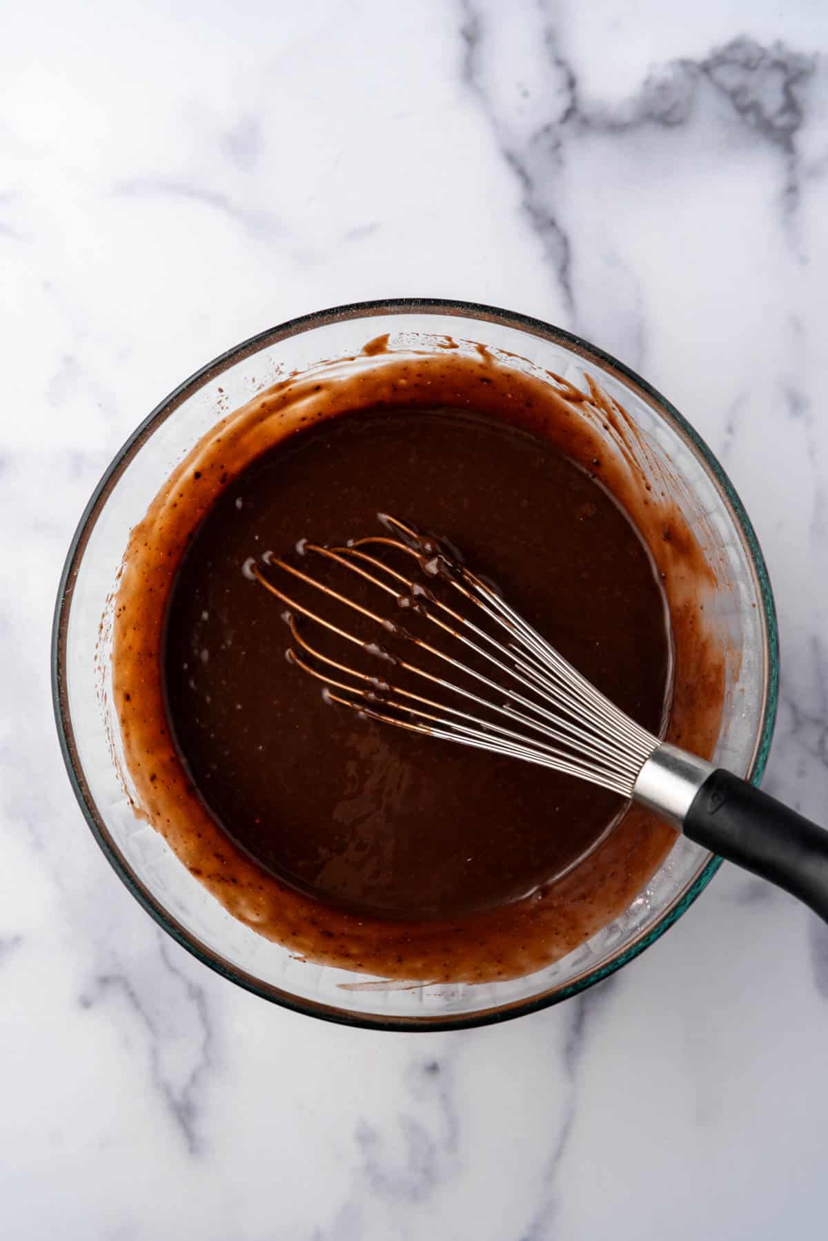 Chocolate pudding in a bowl with a whisk.