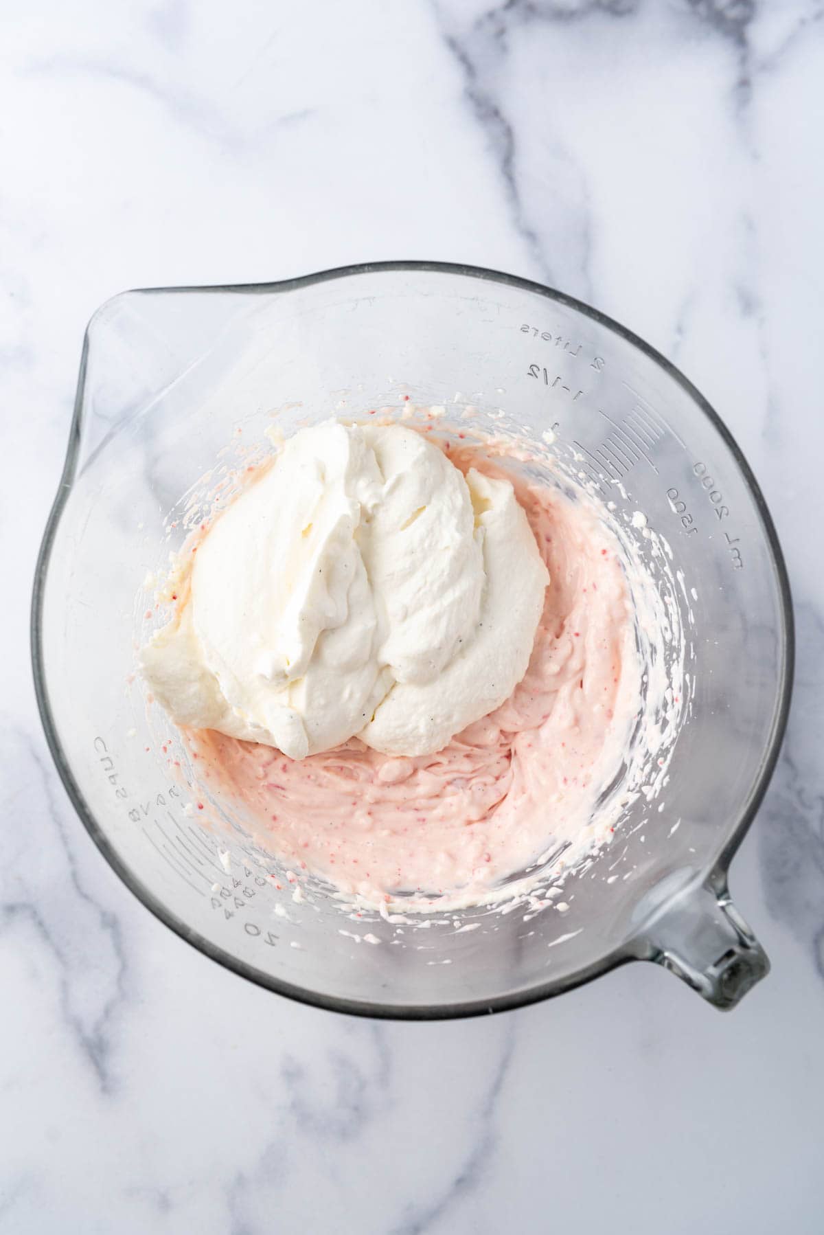 Adding whipped cream to peppermint cheesecake filling.