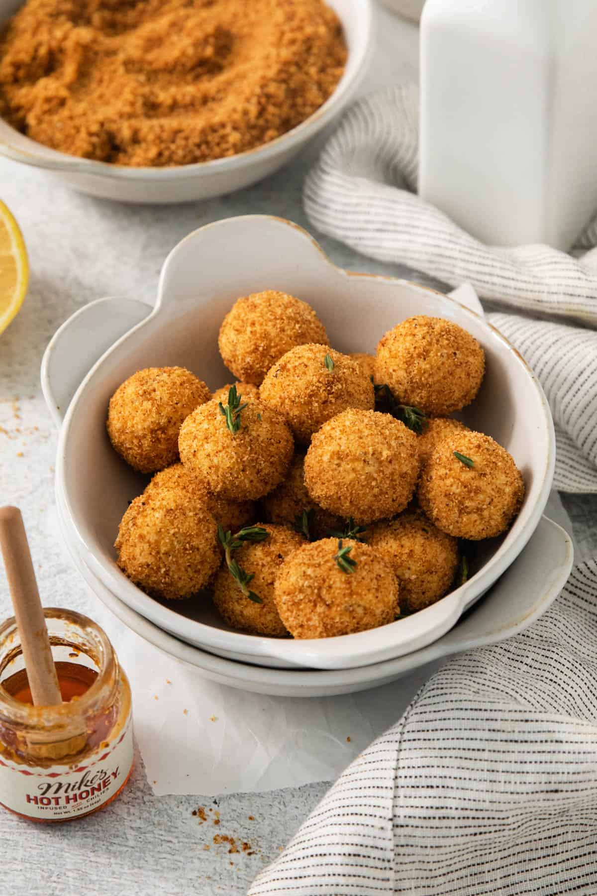 Nested white bowls with crispy goat cheese balls in them.