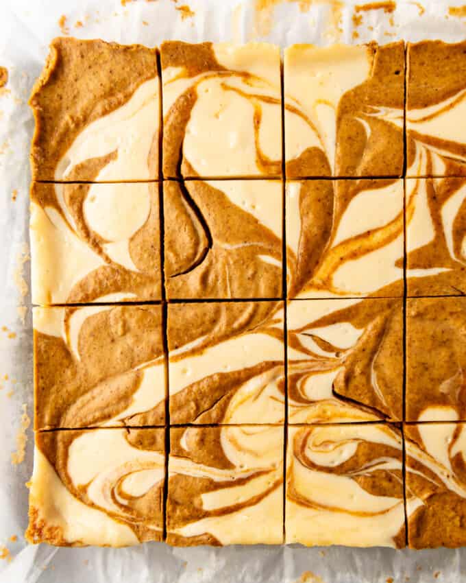 Pumpkin cheesecake bars cut into squares.