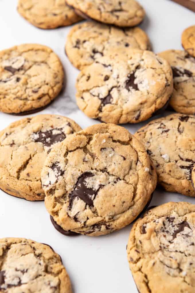 A close image of dark chocolate chunk cookies with flaky salt on top.
