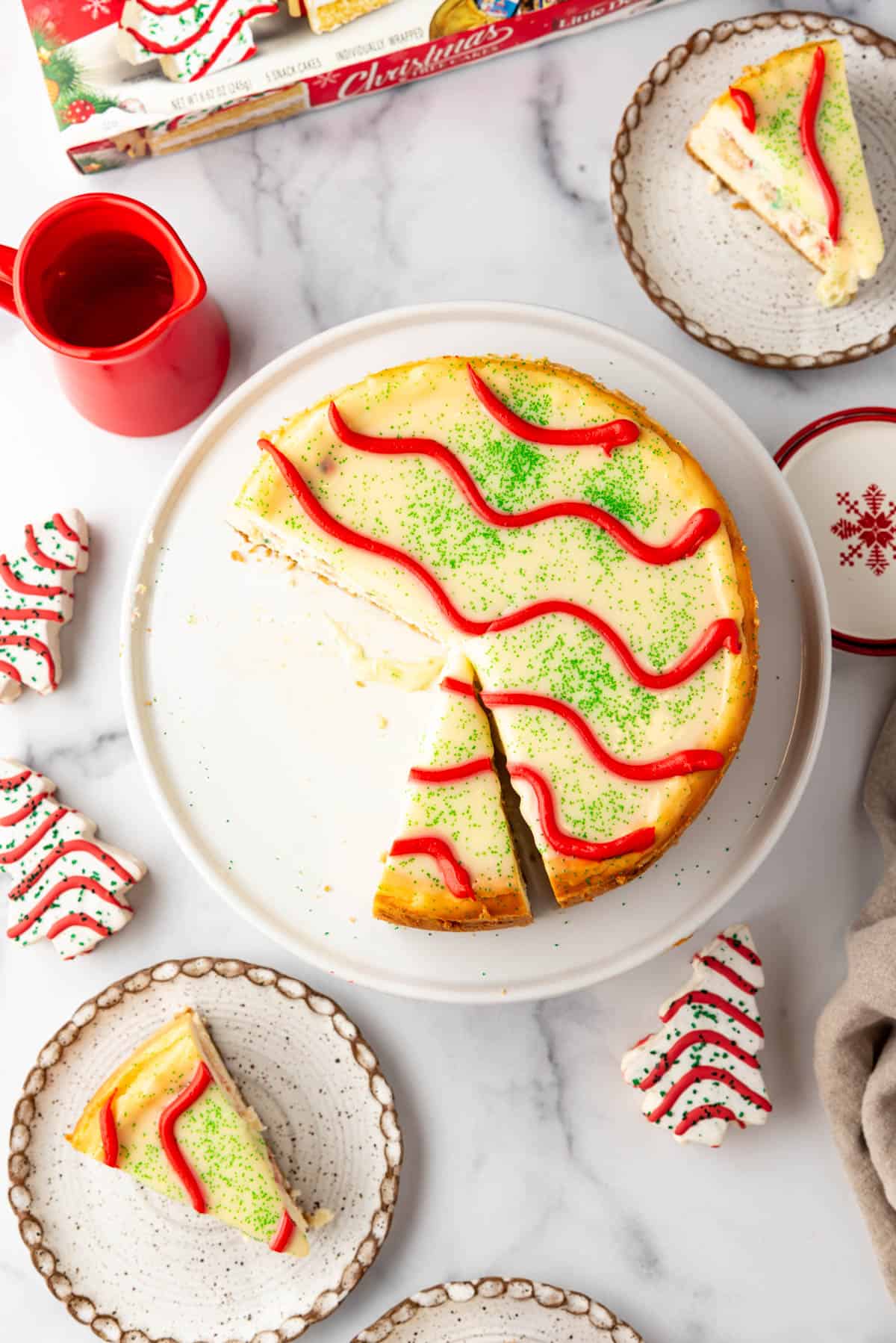An overhead image of a Little Debbie Christmas Tree Cheesecake with some slices taken out of it.