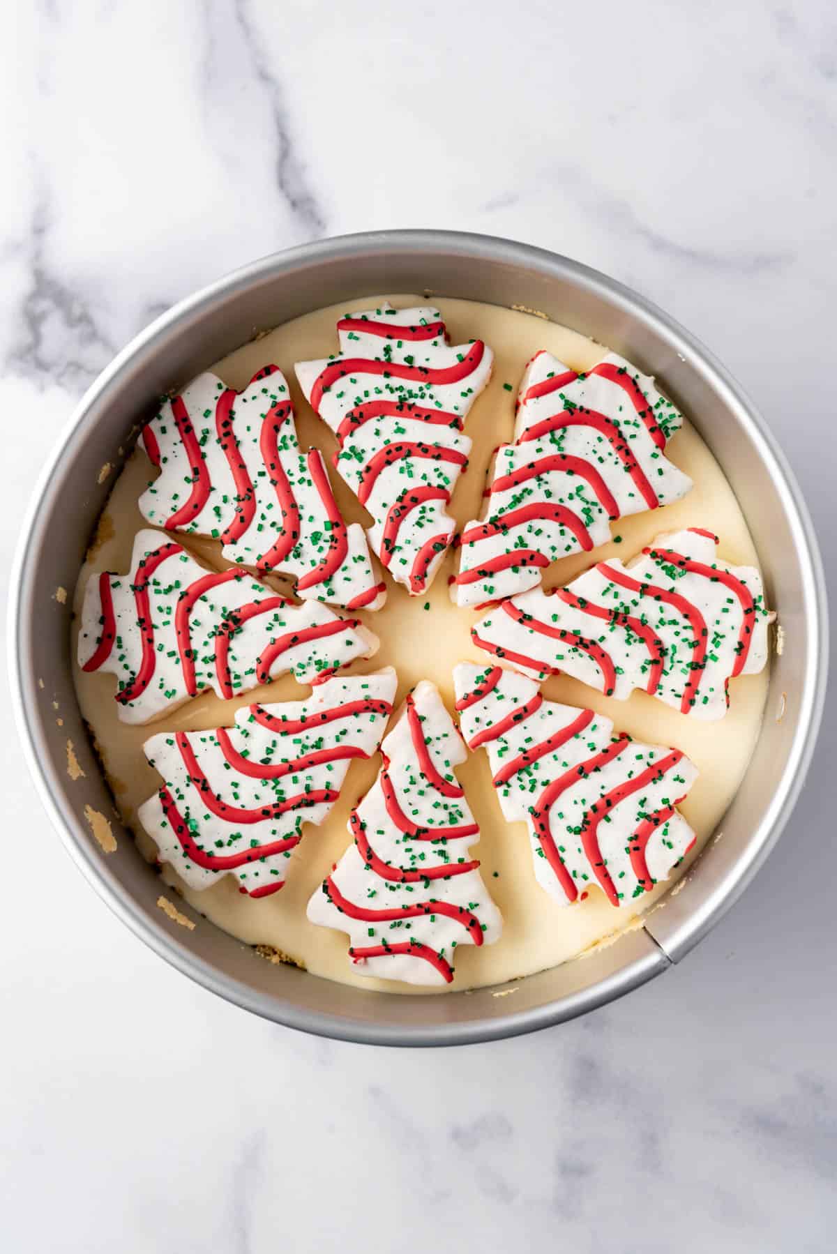 Arranging unwrapped Little Debbie Christmas Tree cakes into a springform pan.