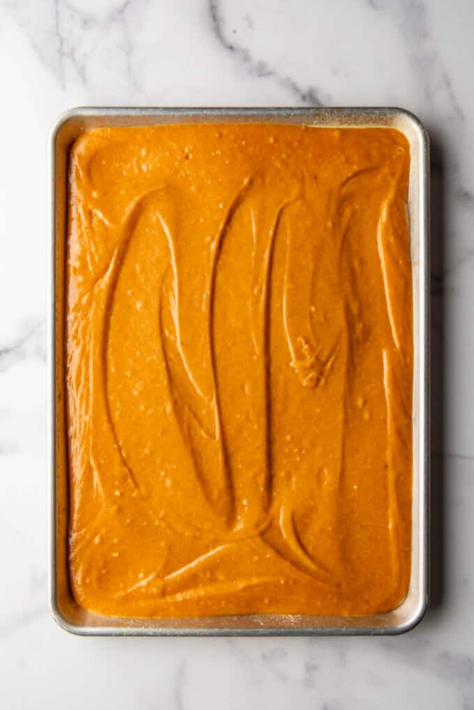 An image of the batter for pumpkin sheet bars spread in a cookie sheet ready to bake.