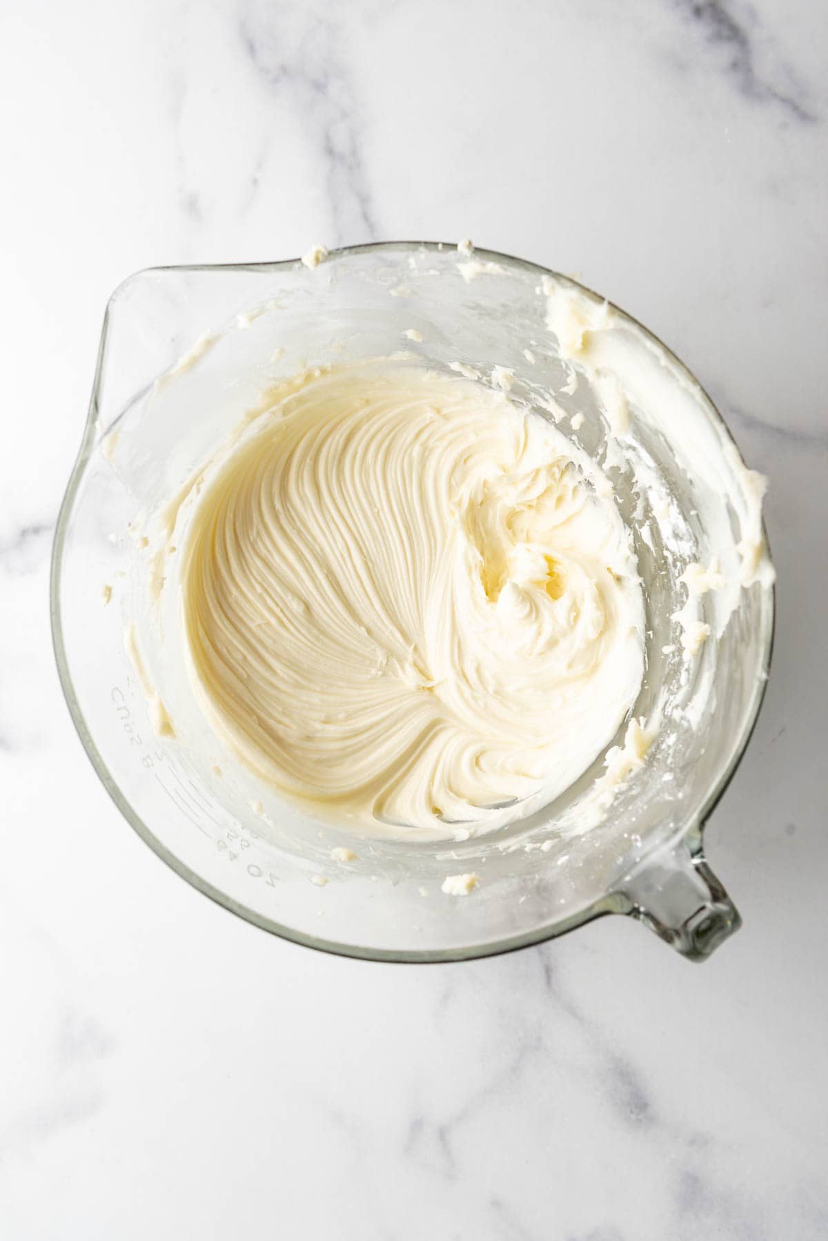 An image of cream cheese frosting freshly mixed in a mixing bowl.