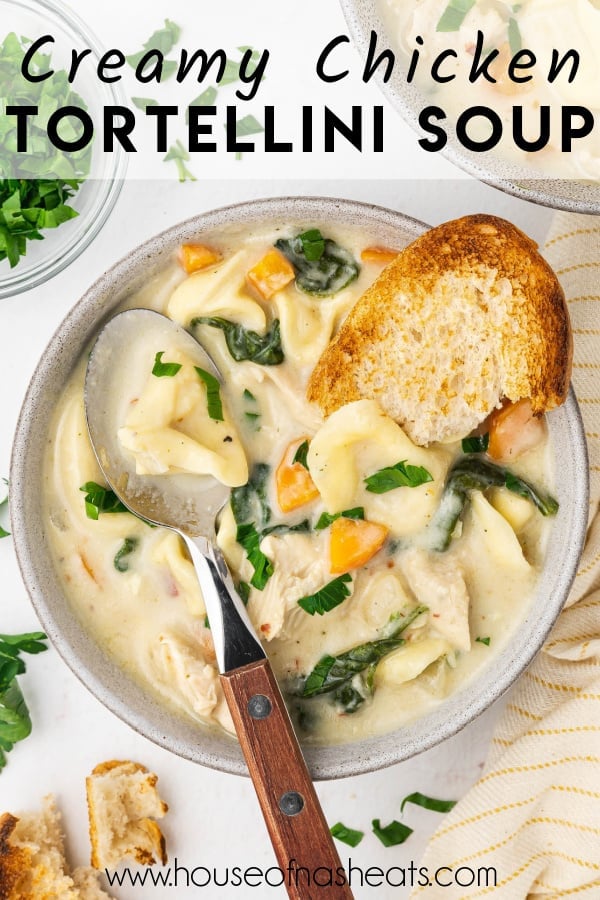 An overhead shot of a spoon and piece of crusty bread in a bowl of chicken tortellini soup with text overlay.
