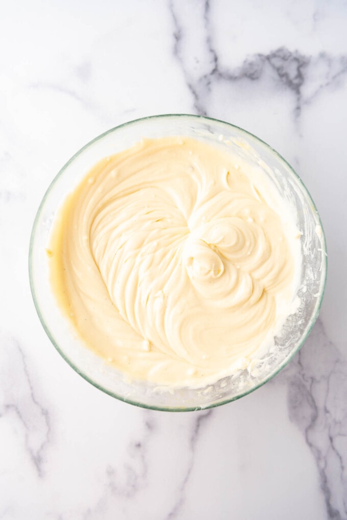 Cheesecake batter in a glass mixing bowl.