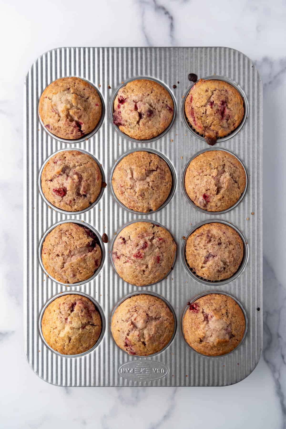 Baked cranberry sauce muffins in a muffin pan.