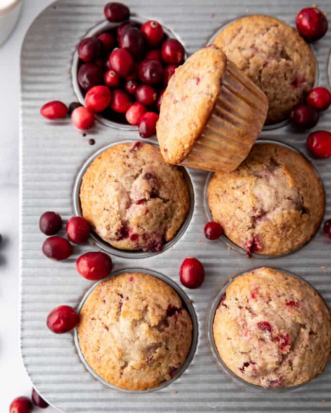 An overhead image of cranberry sauce muffins with fresh cranberries around.