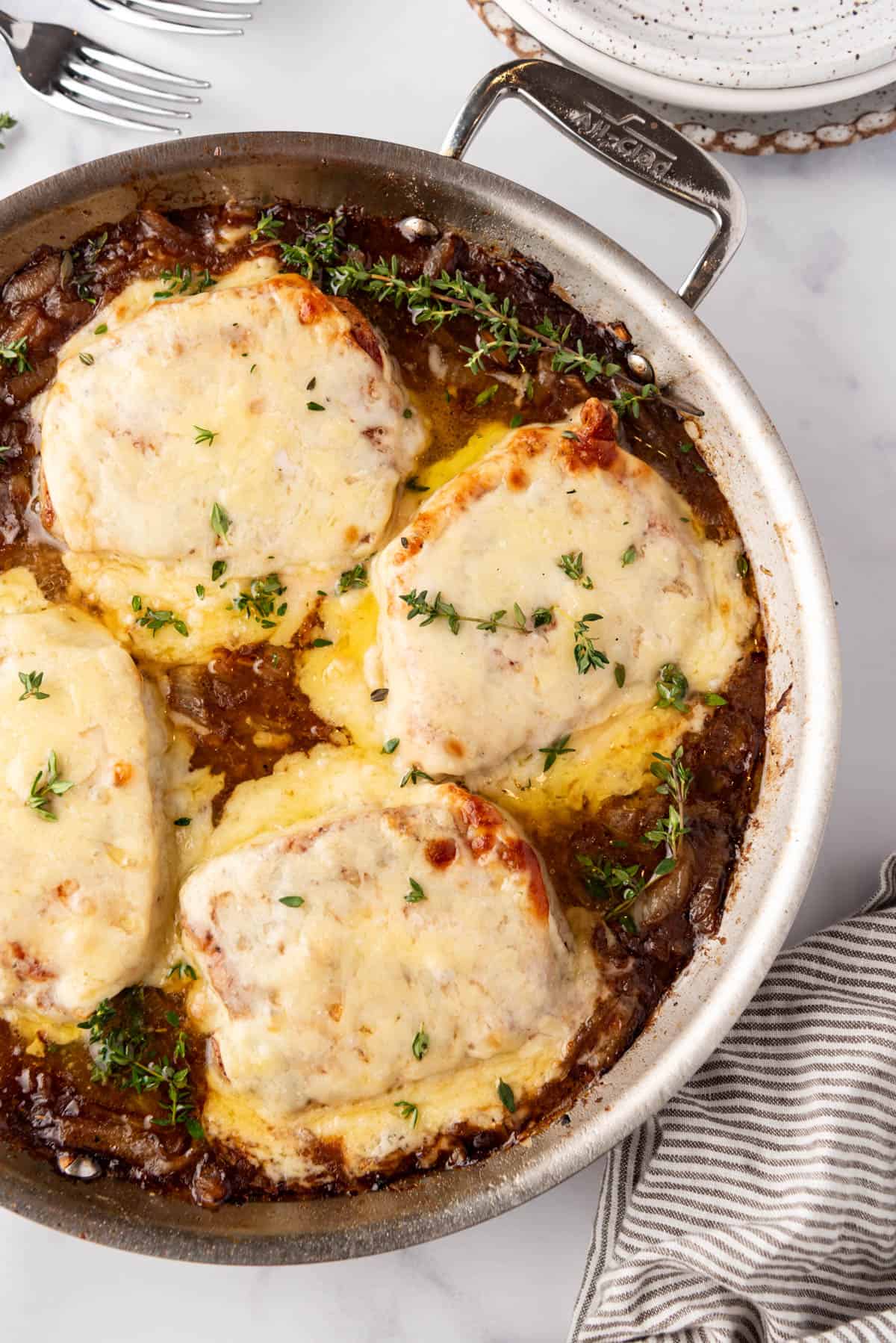 French onion pork chops in a pan.