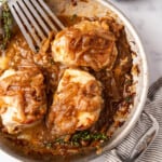 An overhead image of French onion pork chops in a pan with caramelized onions on top.