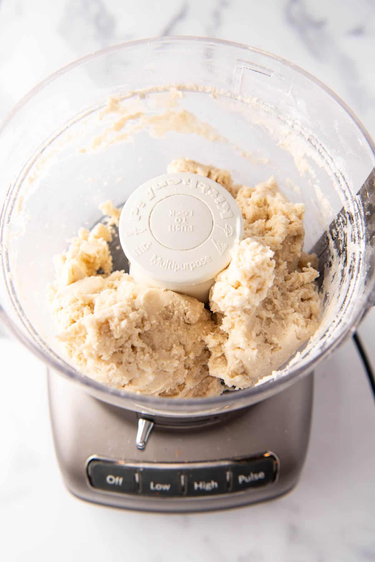 Pie dough after adding cold water in a food processor.