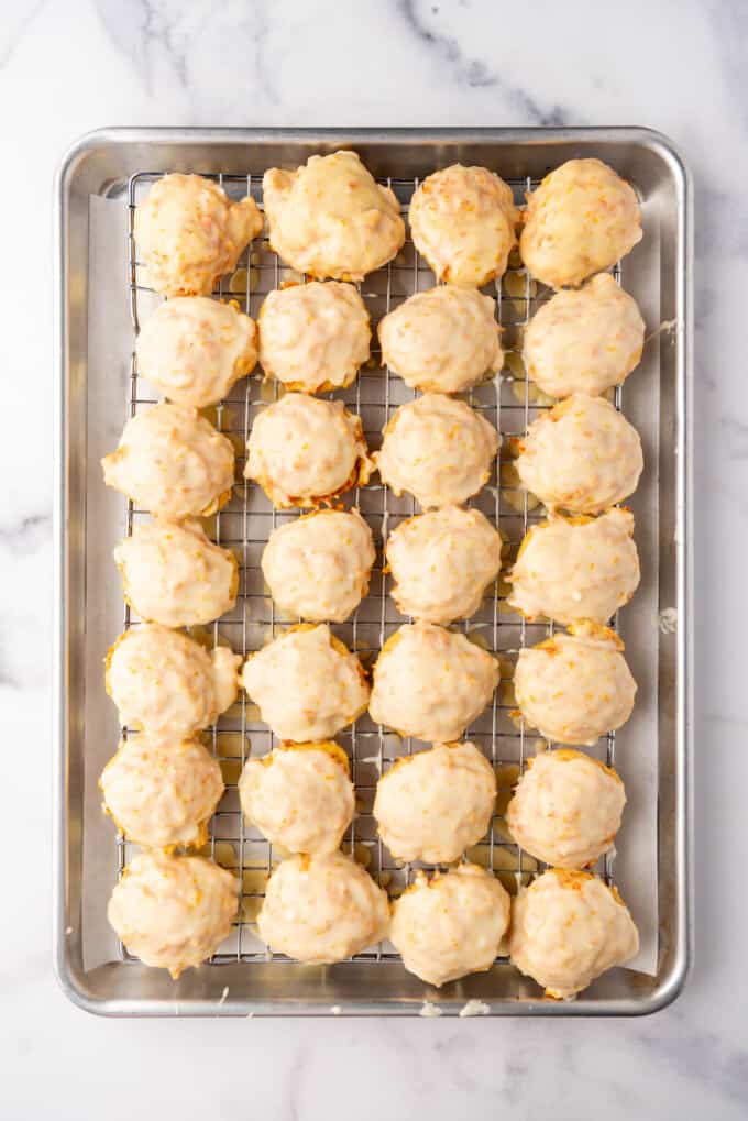 Glazed carrot cookies on a wire rack set over a baking sheet for easy cleanup.