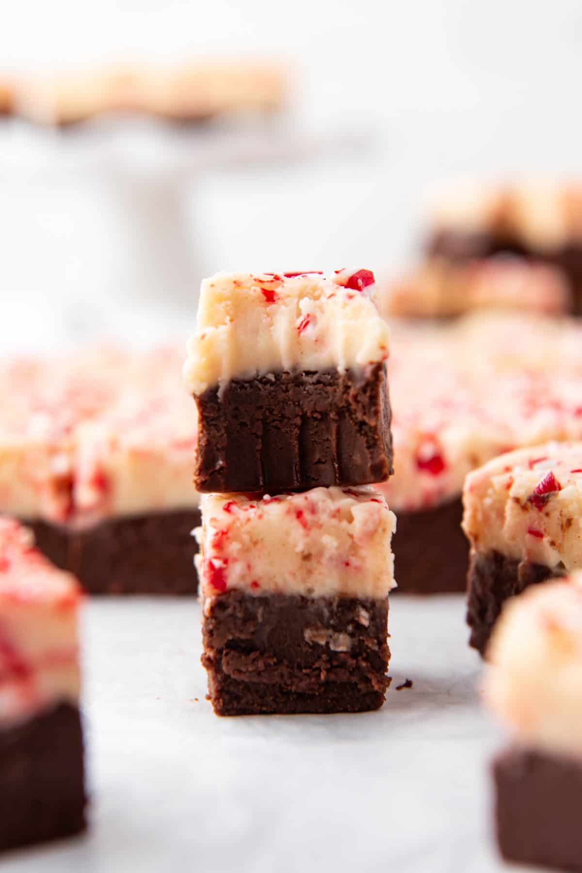 Two pieces of peppermint bark fudge with one stacked on top of the other.