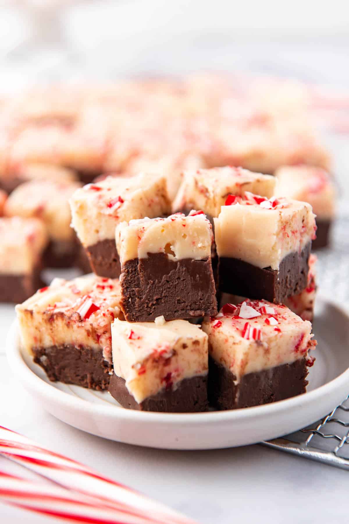 A plate stacked with squares of peppermint bark fudge.
