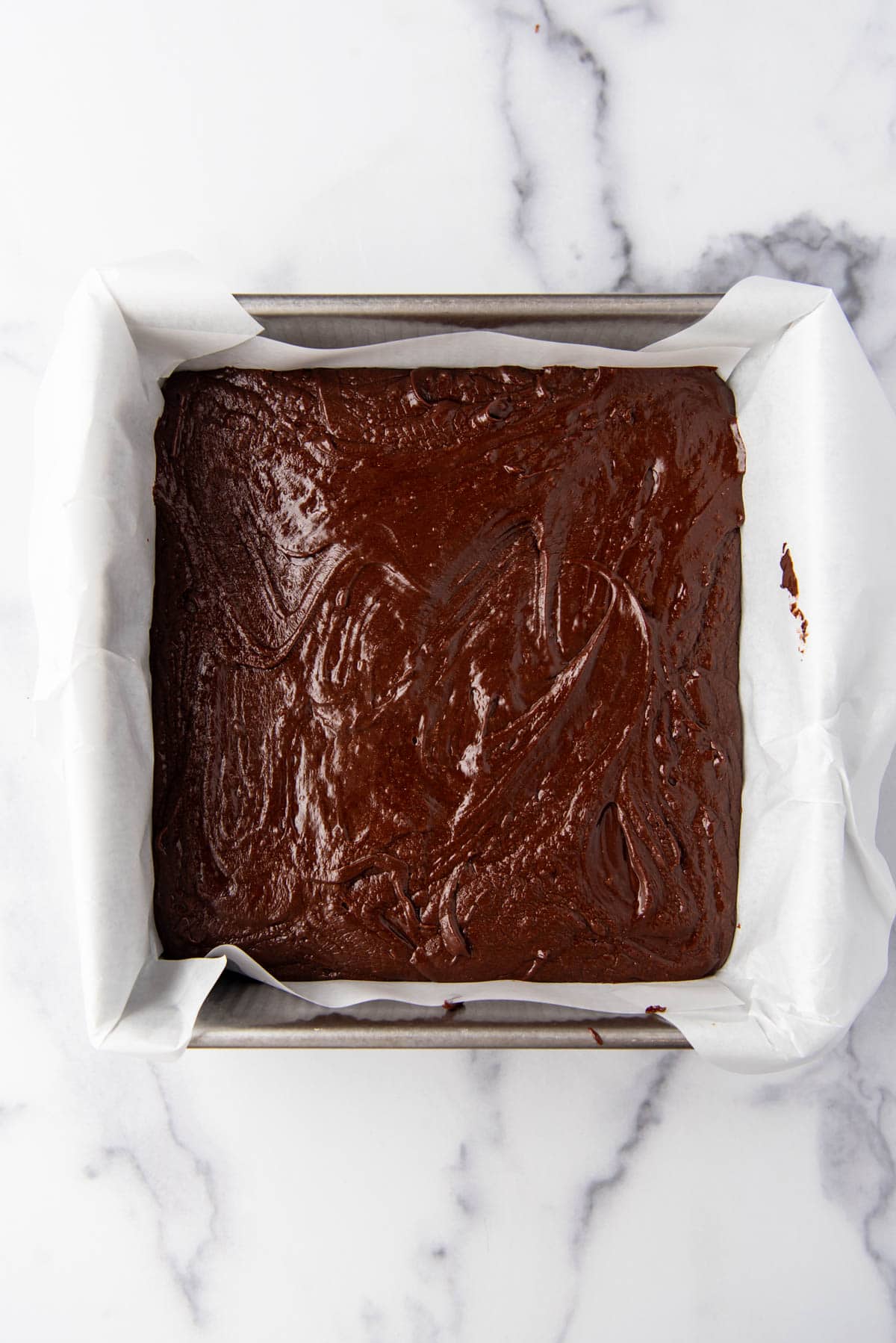 A layer of dark chocolate fudge in a 9-inch square pan.