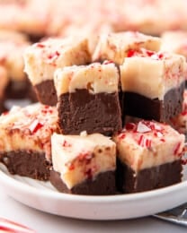 A plate stacked with squares of peppermint bark fudge.