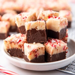 A plate stacked with squares of peppermint bark fudge.