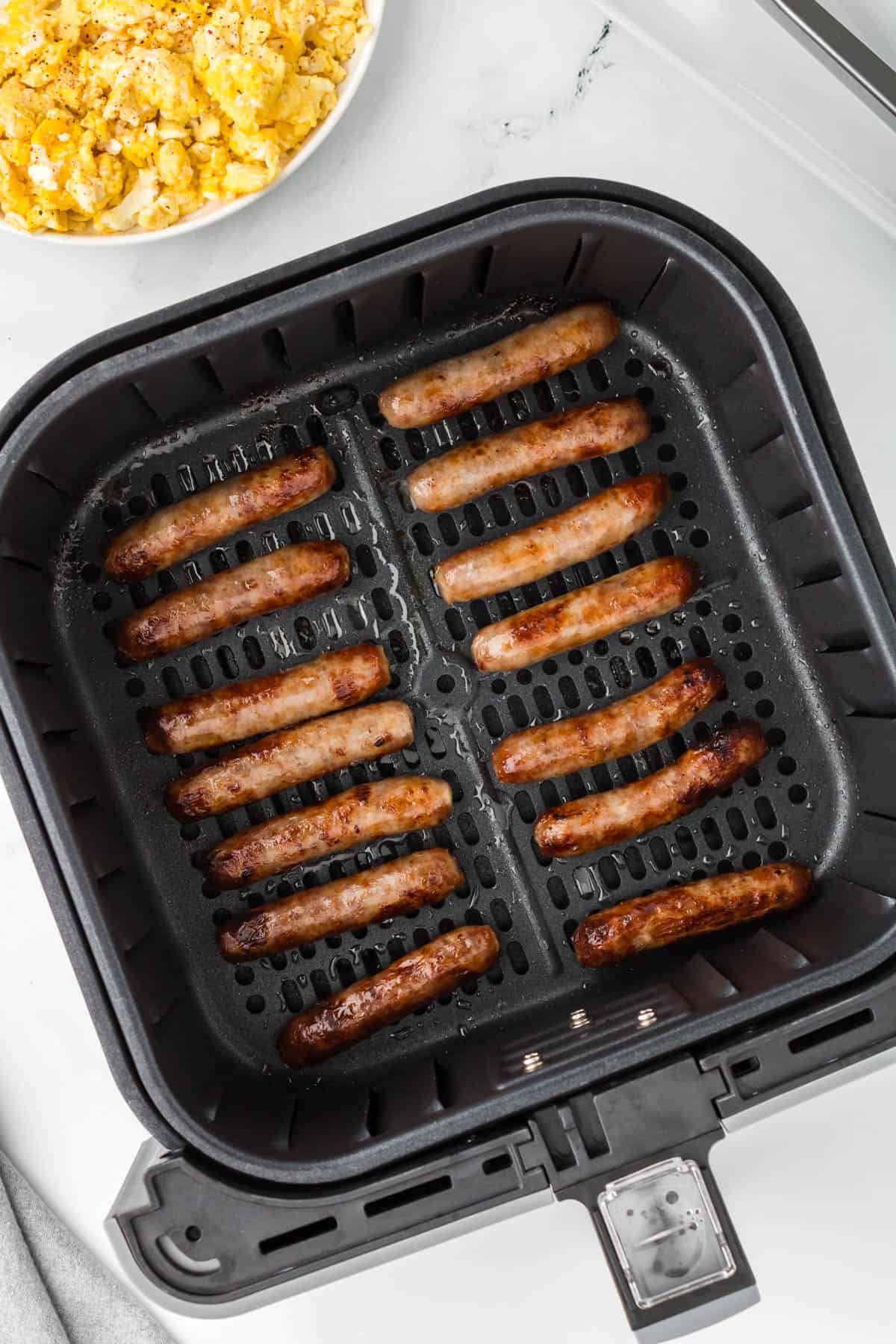 An overhead image of air fryer breakfast sausages in the air fryer basket.