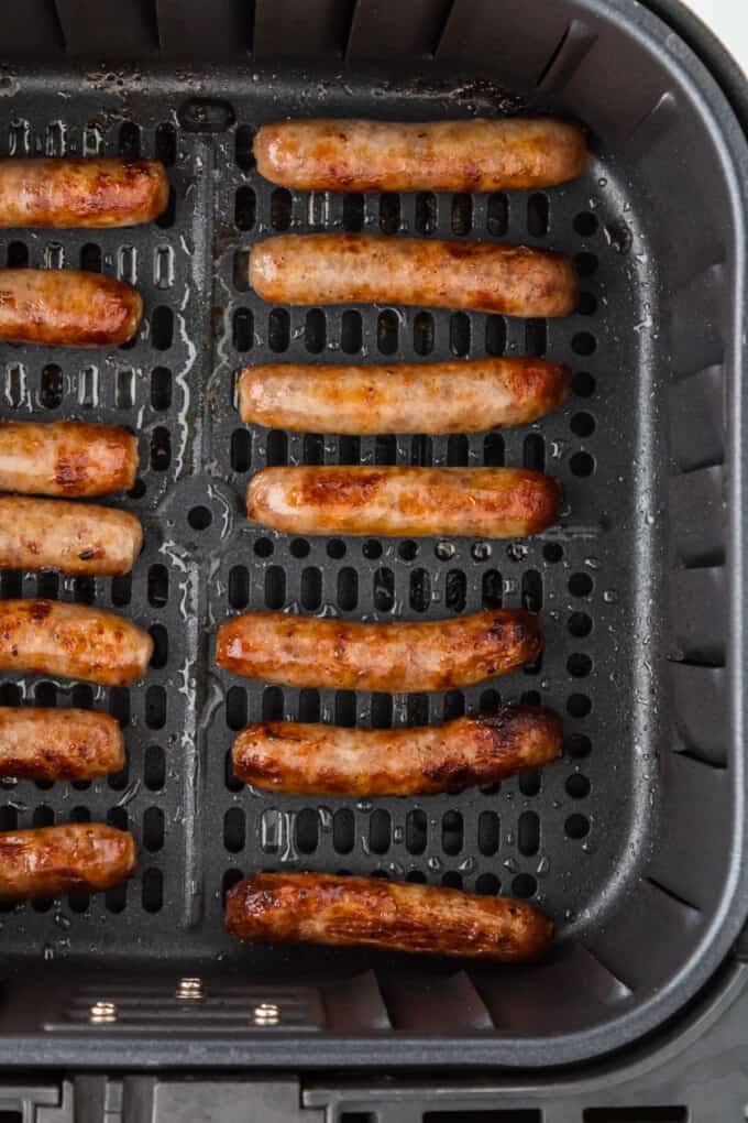 A close image of air fryer sausage links in the air fryer basket.