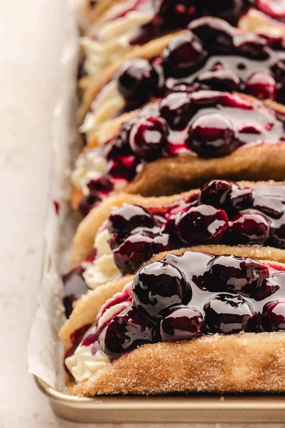 A close image of blueberry cheesecake pie filling on blueberry cheesecake tacos.
