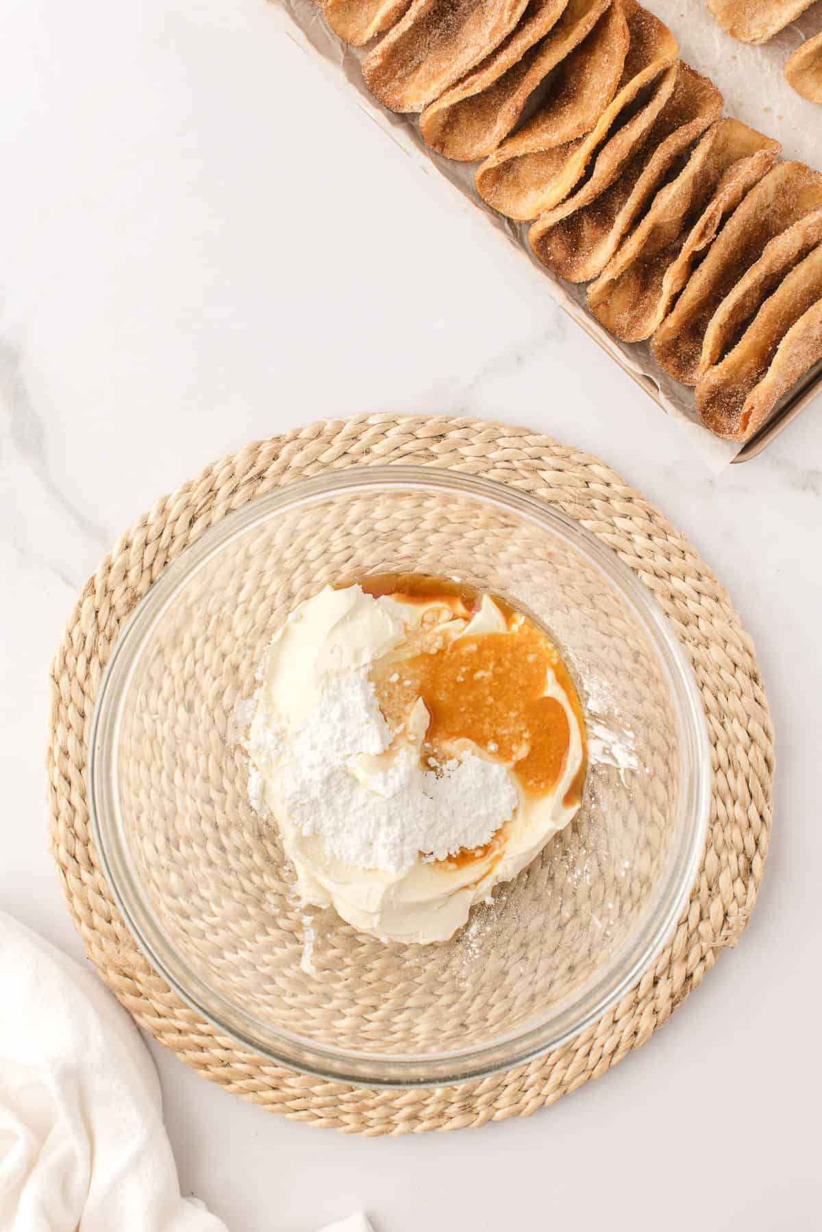 Combining sour cream, sugar, and vanilla extract in a glass mixing bowl.