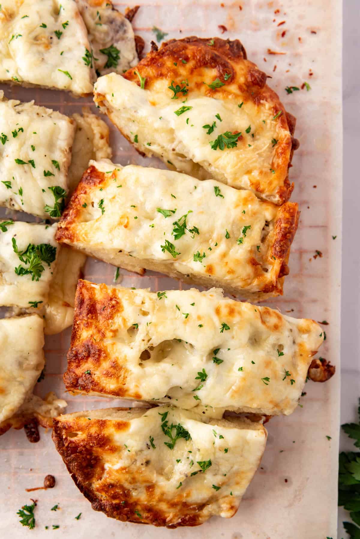 An overhead image of slices of cheesy garlic bread.