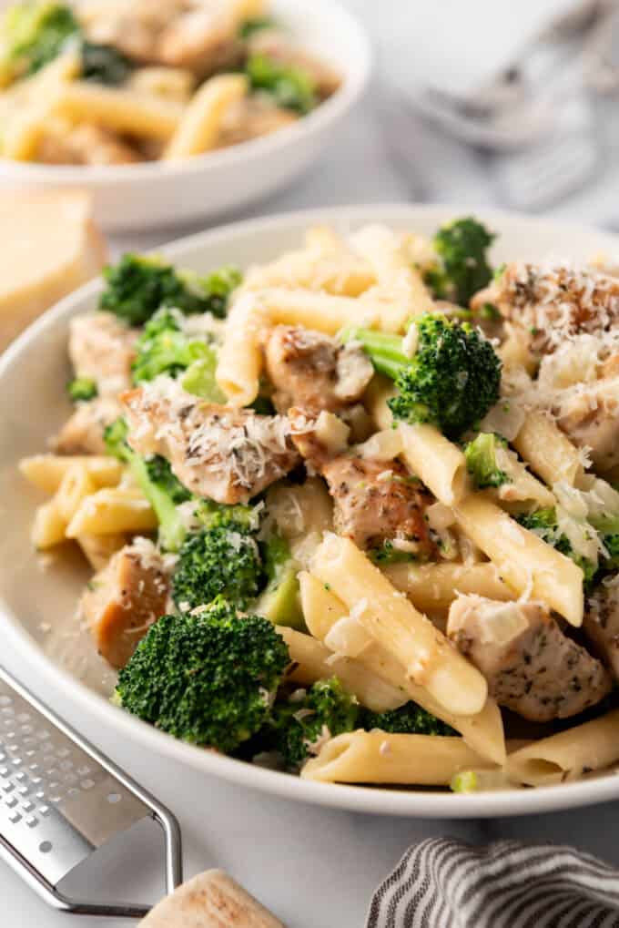 A big bowl of penne pasta with chicken and broccoli.