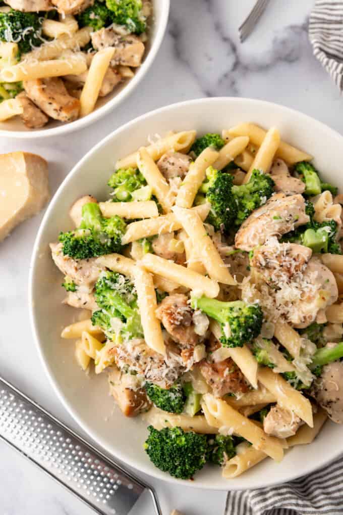 Penne pasta with cooked chicken pieces and broccoli in a creamy garlic sauce.
