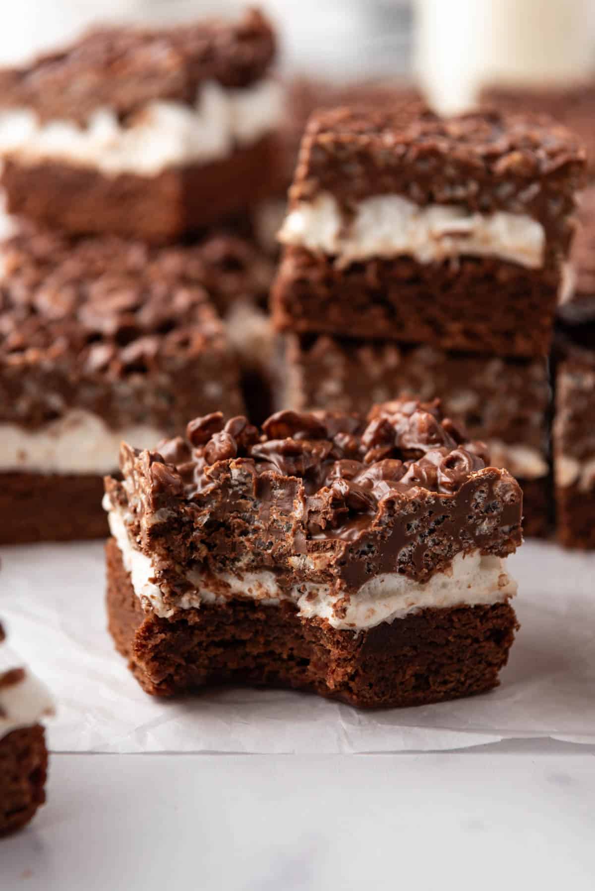 An image of a chocolate peanut butter crunch brownie with marshmallows with a bite taken out of one corner.