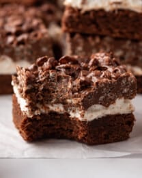 An image of a chocolate peanut butter crunch brownie with marshmallows with a bite taken out of one corner.