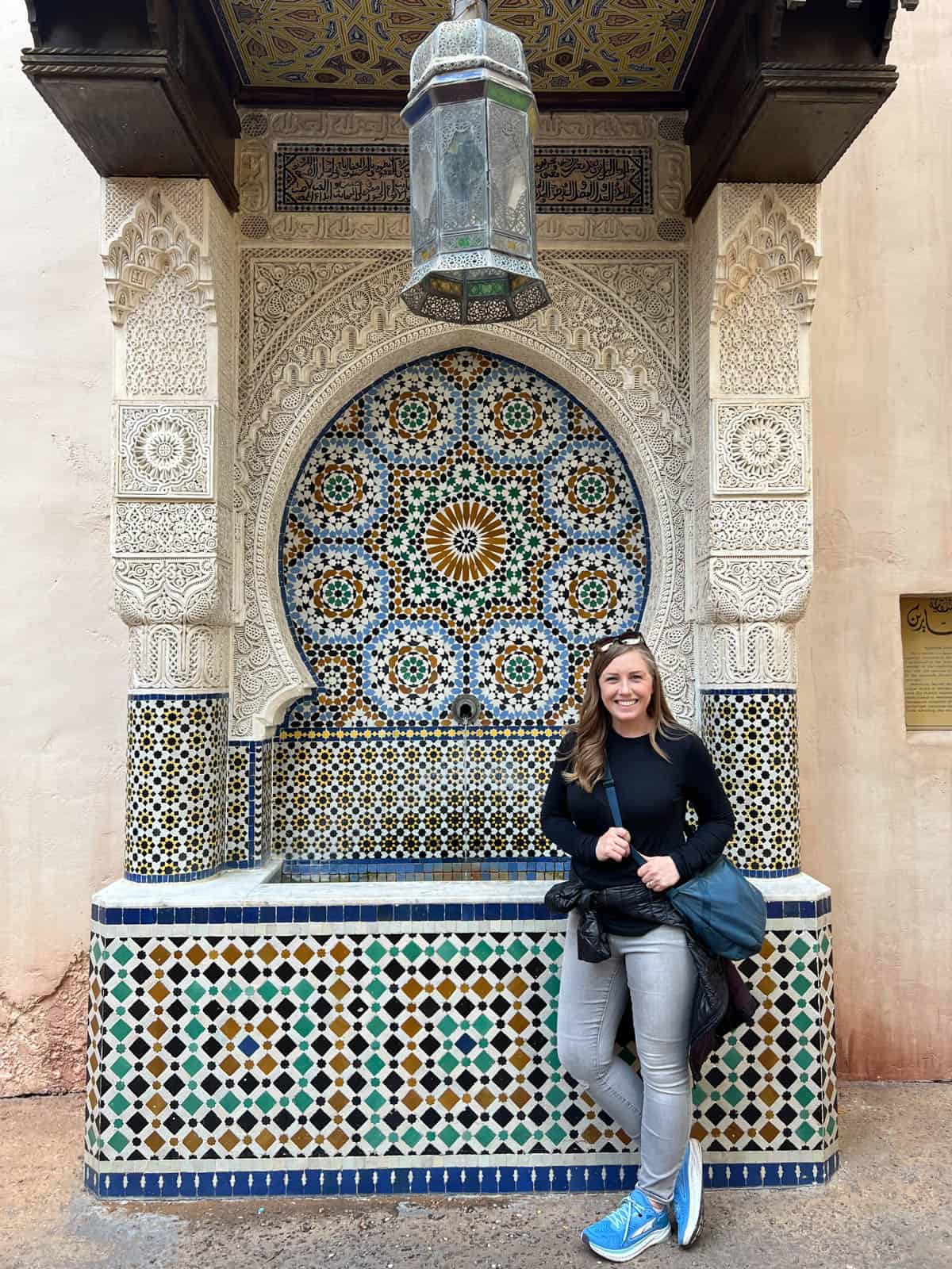 A woman in front of a mosaic tiled fountain in the Morocco section at Epcot.