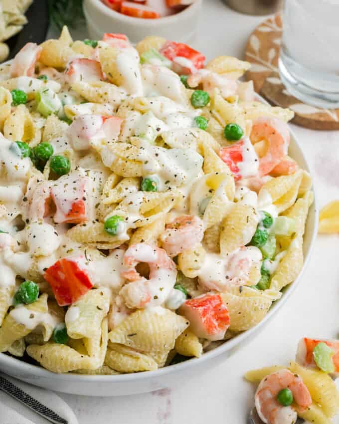 A close up image of seafood pasta salad in a large serving bowl.