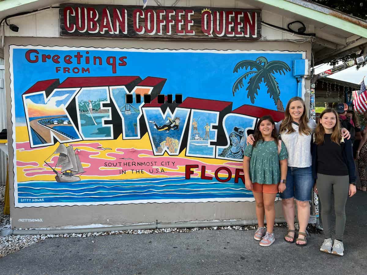 An image of a mom and two girls in front of the Key West Florida sign.