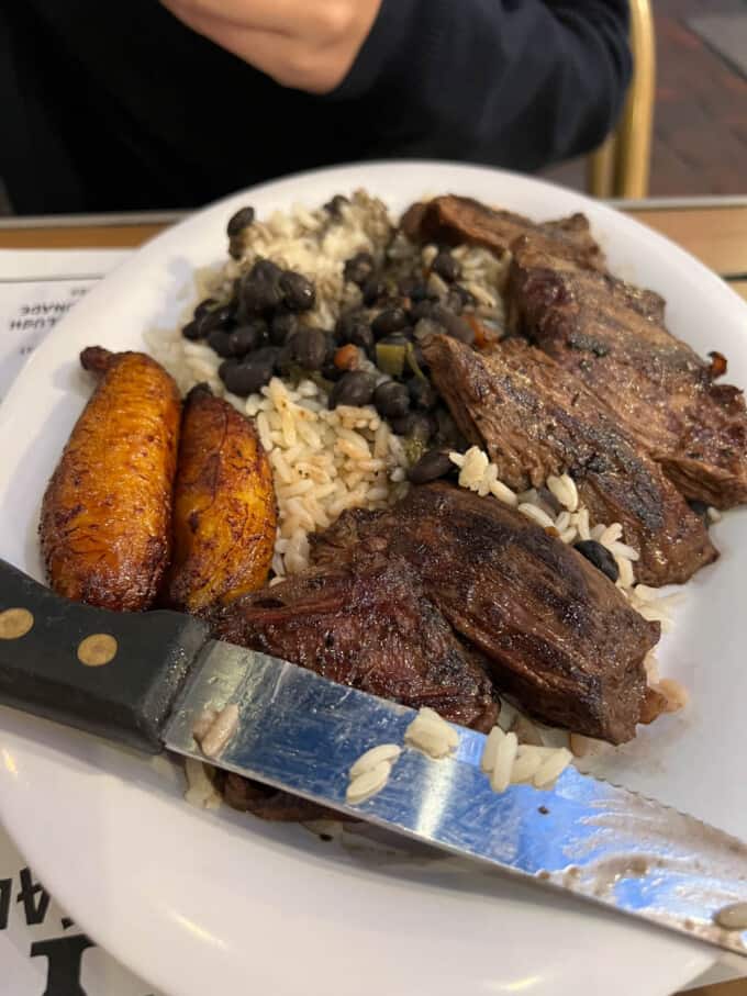 Grilled steak with plantains and rice on a plate.