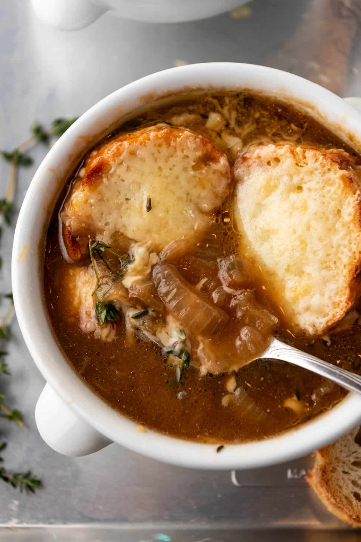 A spoon in a bowl of French onion soup.