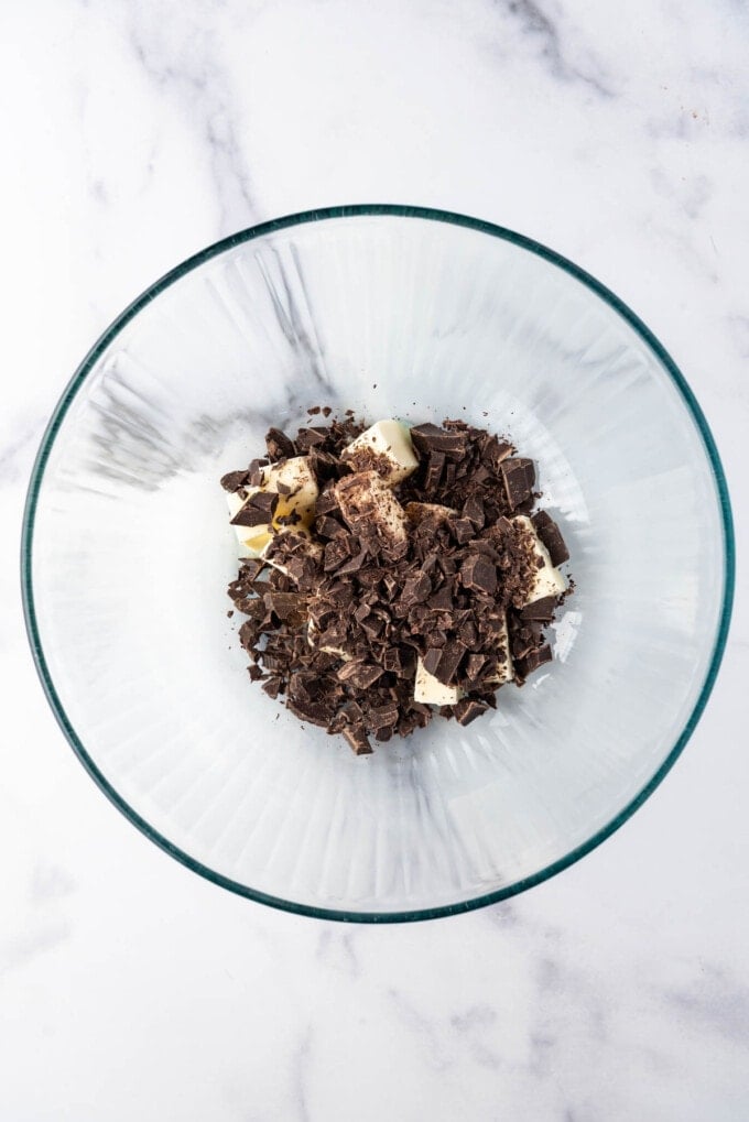 Chopped chocolate and butter in a microwave-safe mixing bowl.
