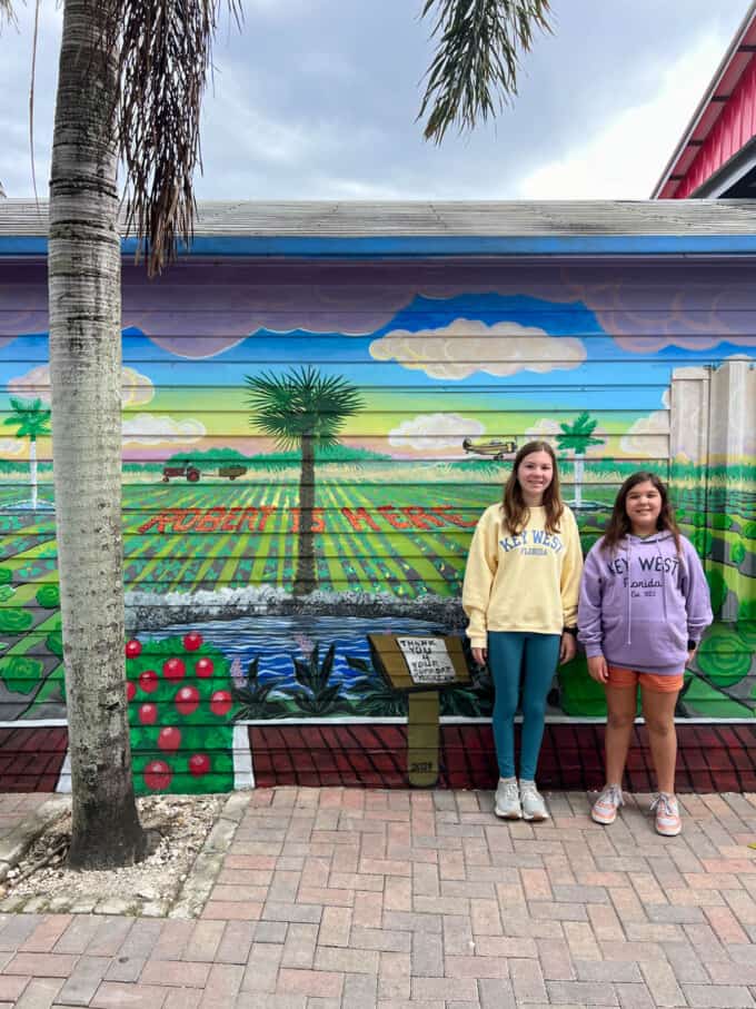 An image in front of the Robert is Here mural at a fruit stand in Florida.
