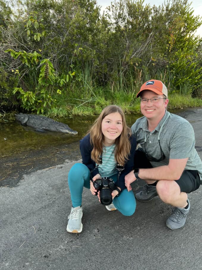 A dad and daughter in front of a crocodile in Everglades National Park.